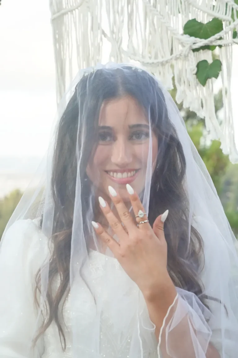 כלה מציגה את טבעת הנישואין מתחת להינומה