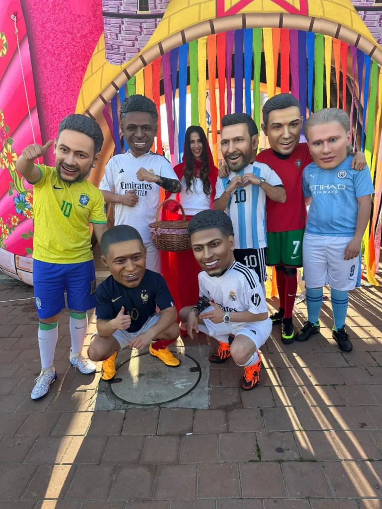 דמויות ענק של שחקני כדורגל עולמיים מצטלמות עם ילדים במסיבת יום הולדת