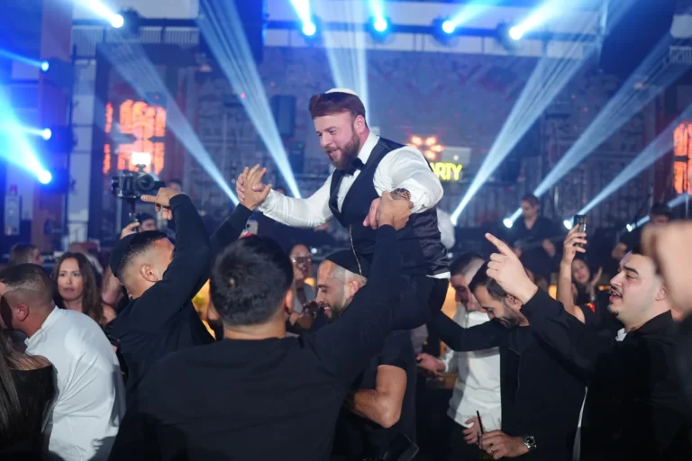 החתן מורם על ידי החברים באורות המסיבה