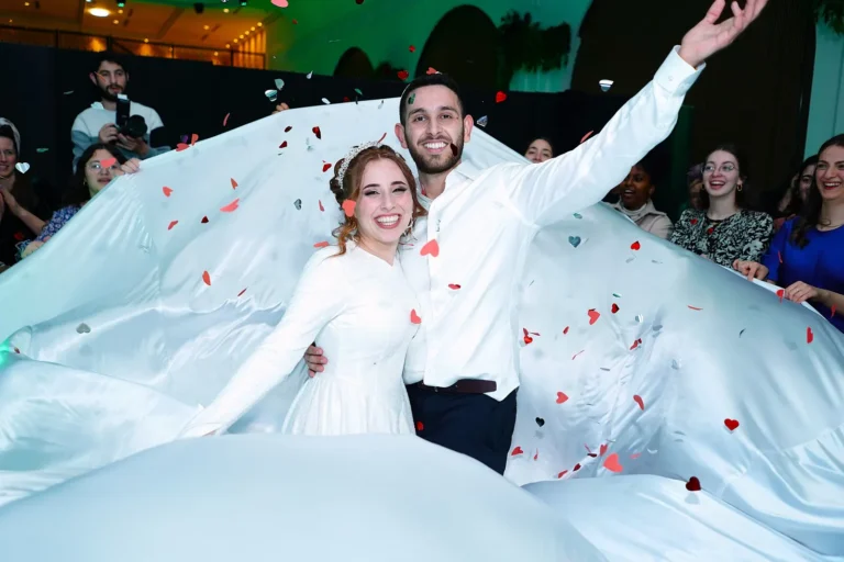 חתן וכלה רוקדים עם קונפטי וינוף שמלה