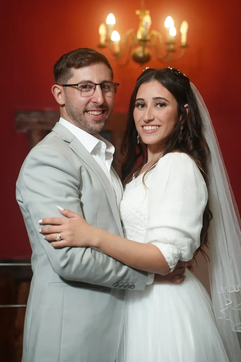חתן וכלה בצילום פורטרט בחדר עם קירות אדומים