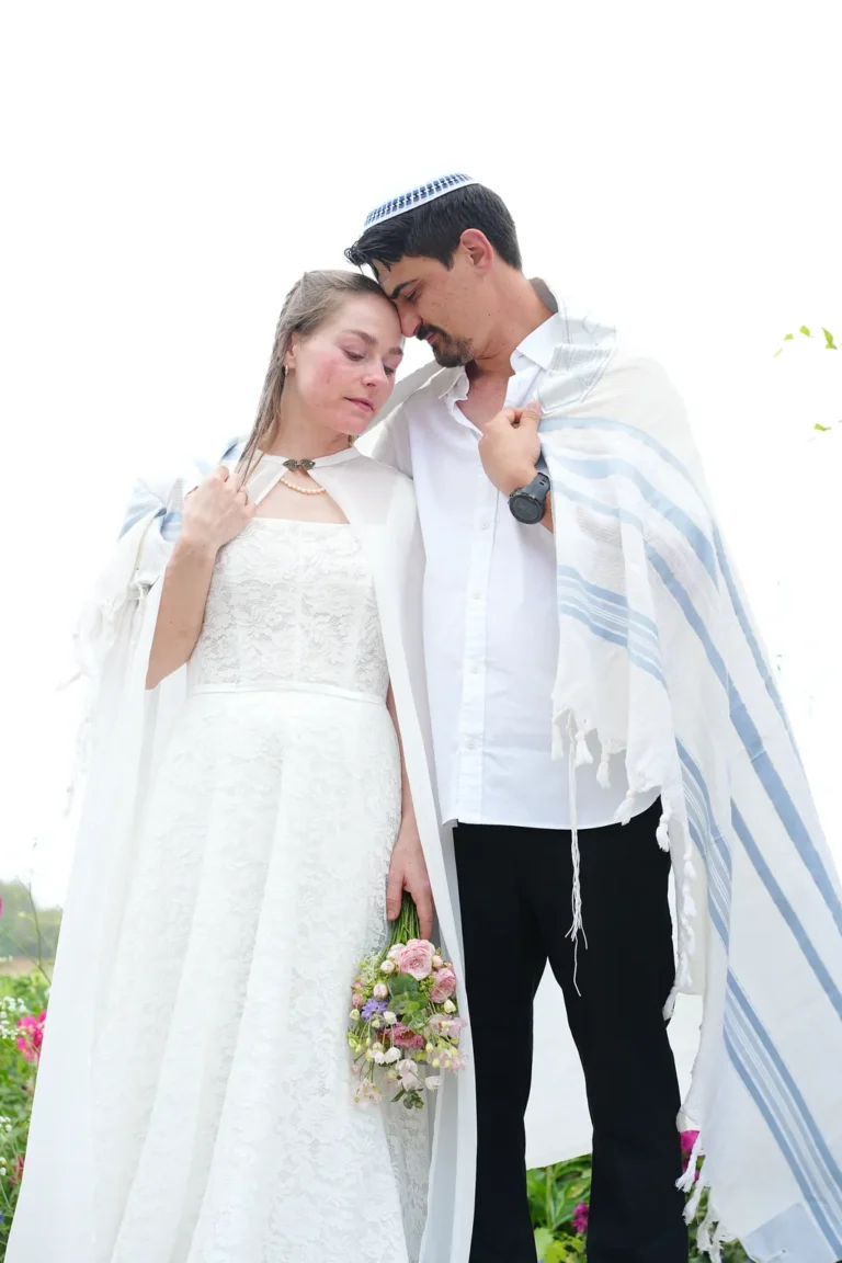 חתן וכלה עטופים בטלית ביום החתונה