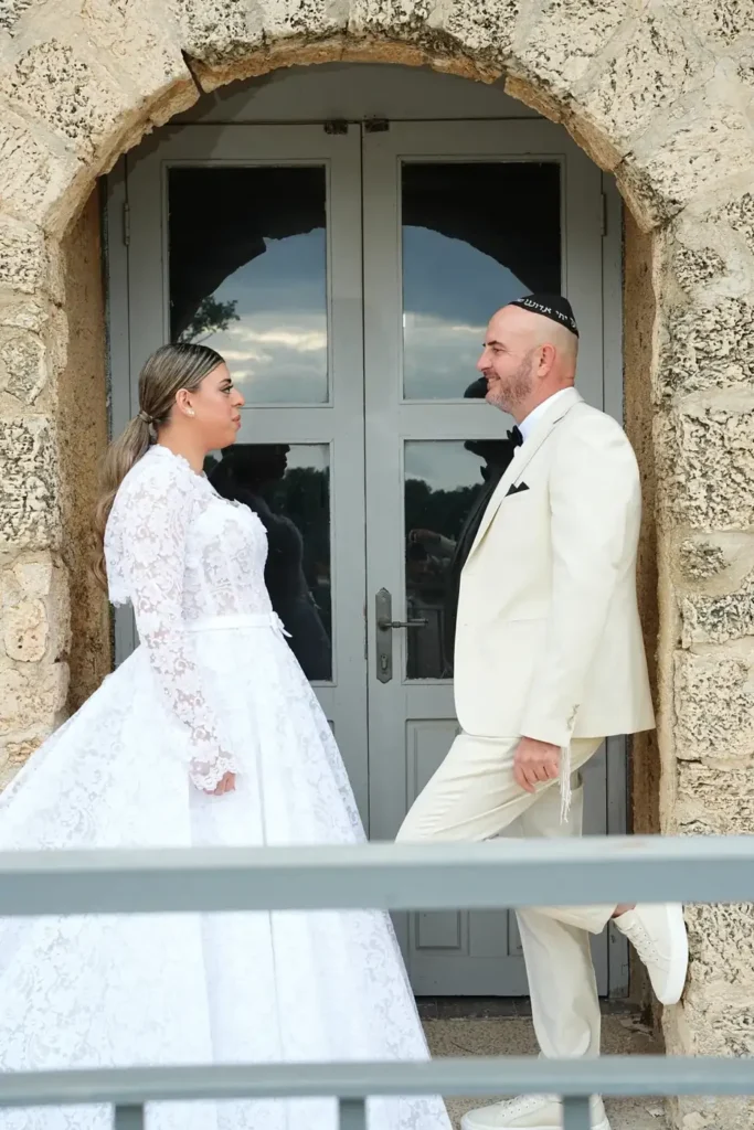 מפגש ראשון של חתן וכלה לפני החתונה ליד דלת עץ