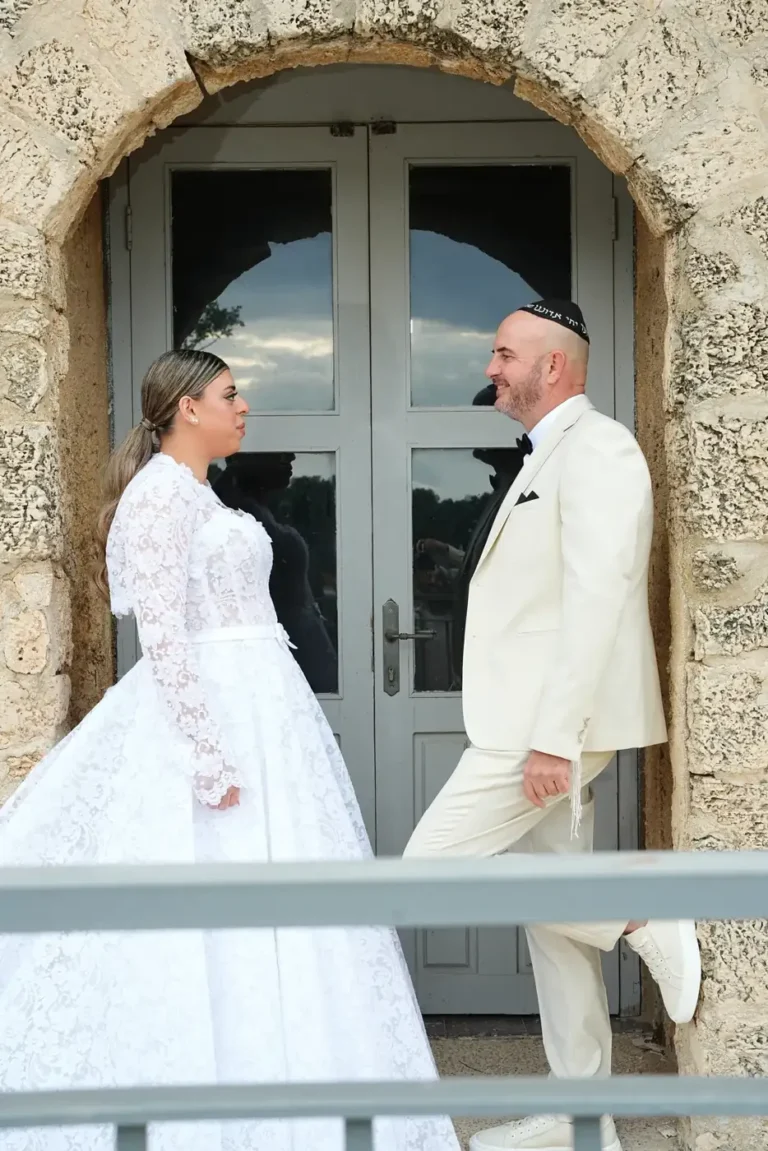 מפגש ראשון של חתן וכלה לפני החתונה ליד דלת עץ